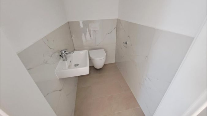 Toilette mit Wand-WC und modenernem Handwaschbecke